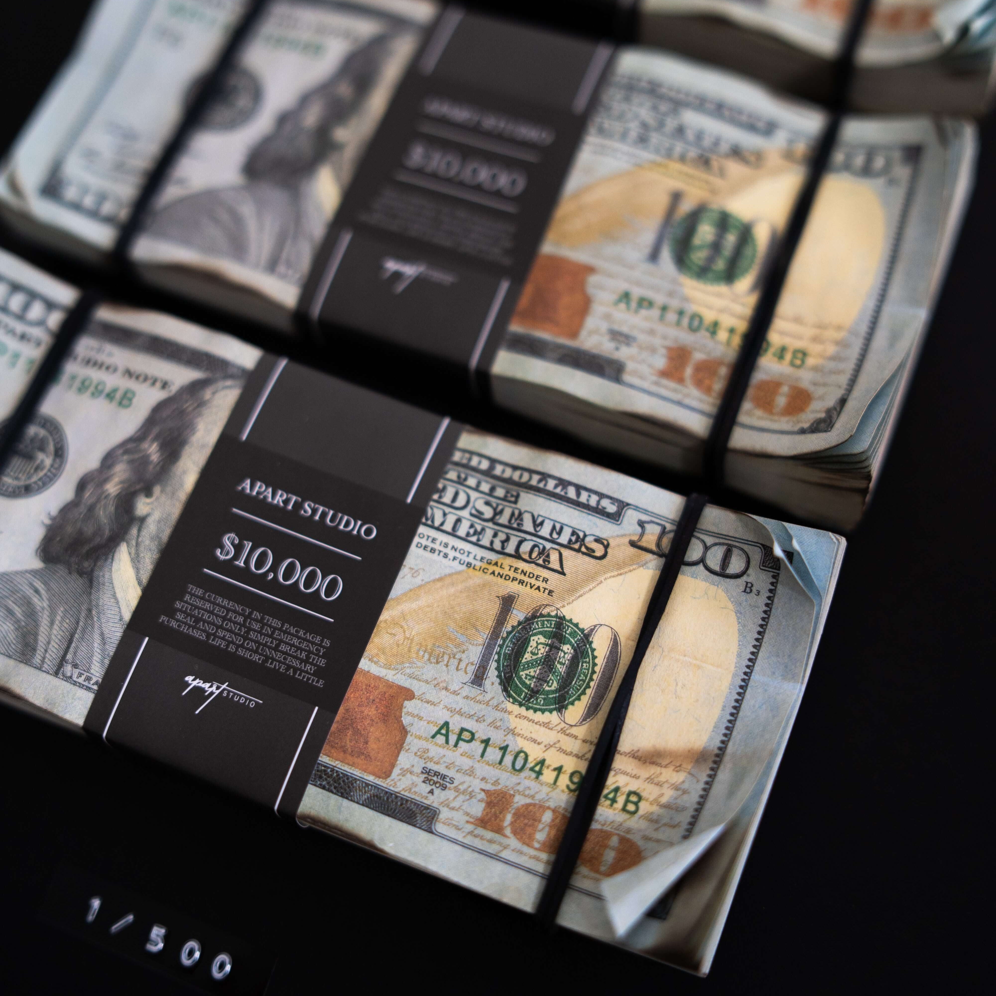 Framed artwork of a $100 bill with a black border on a dark background