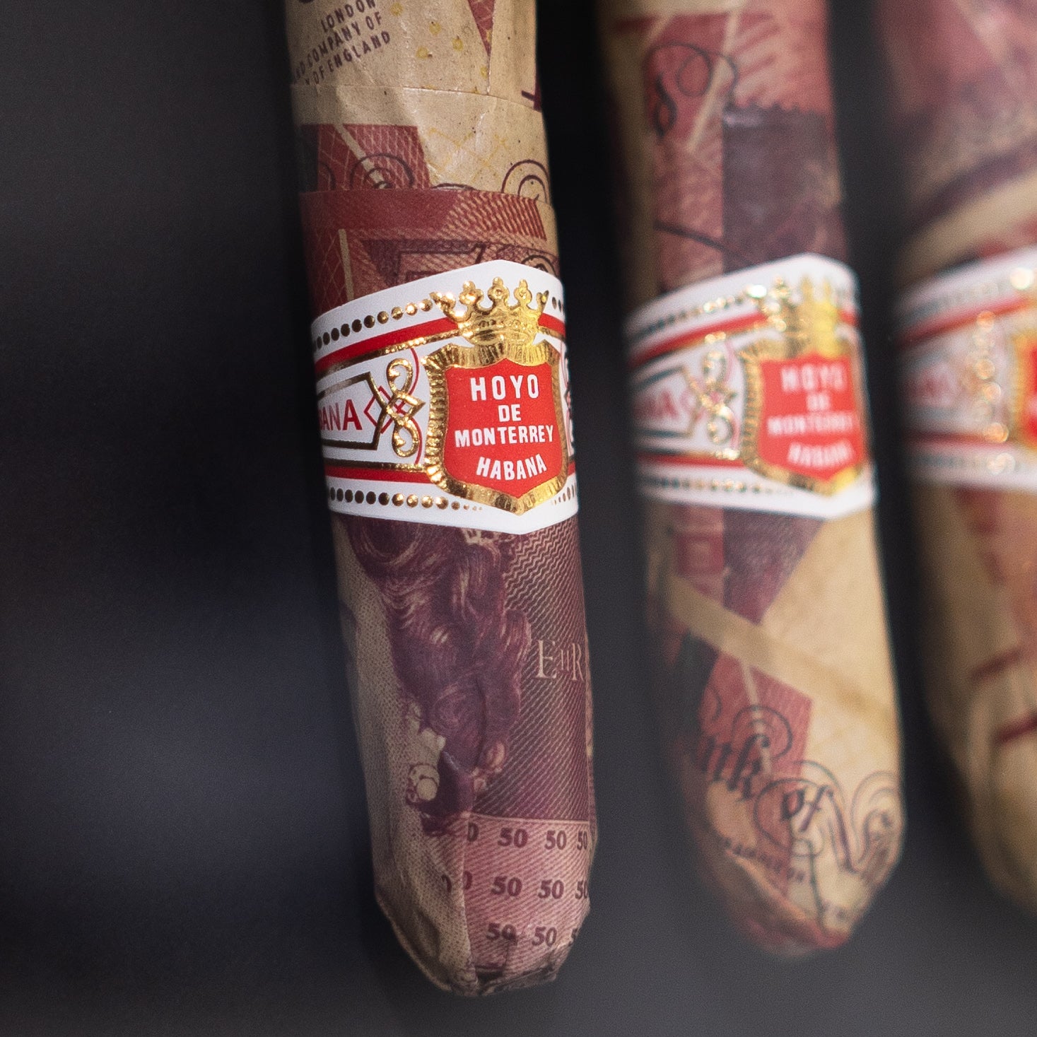 Smoking Bills 2.0 GBP angled view showing handmade cash wrapped cigars behind glass in deep black frame