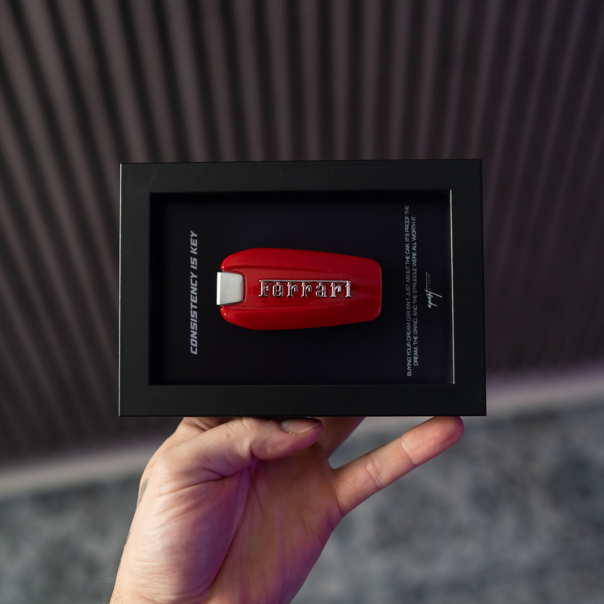 Consistency is Key Ferrari held in hand showing handmade Ferrari badge framed artwork by Apart Studio