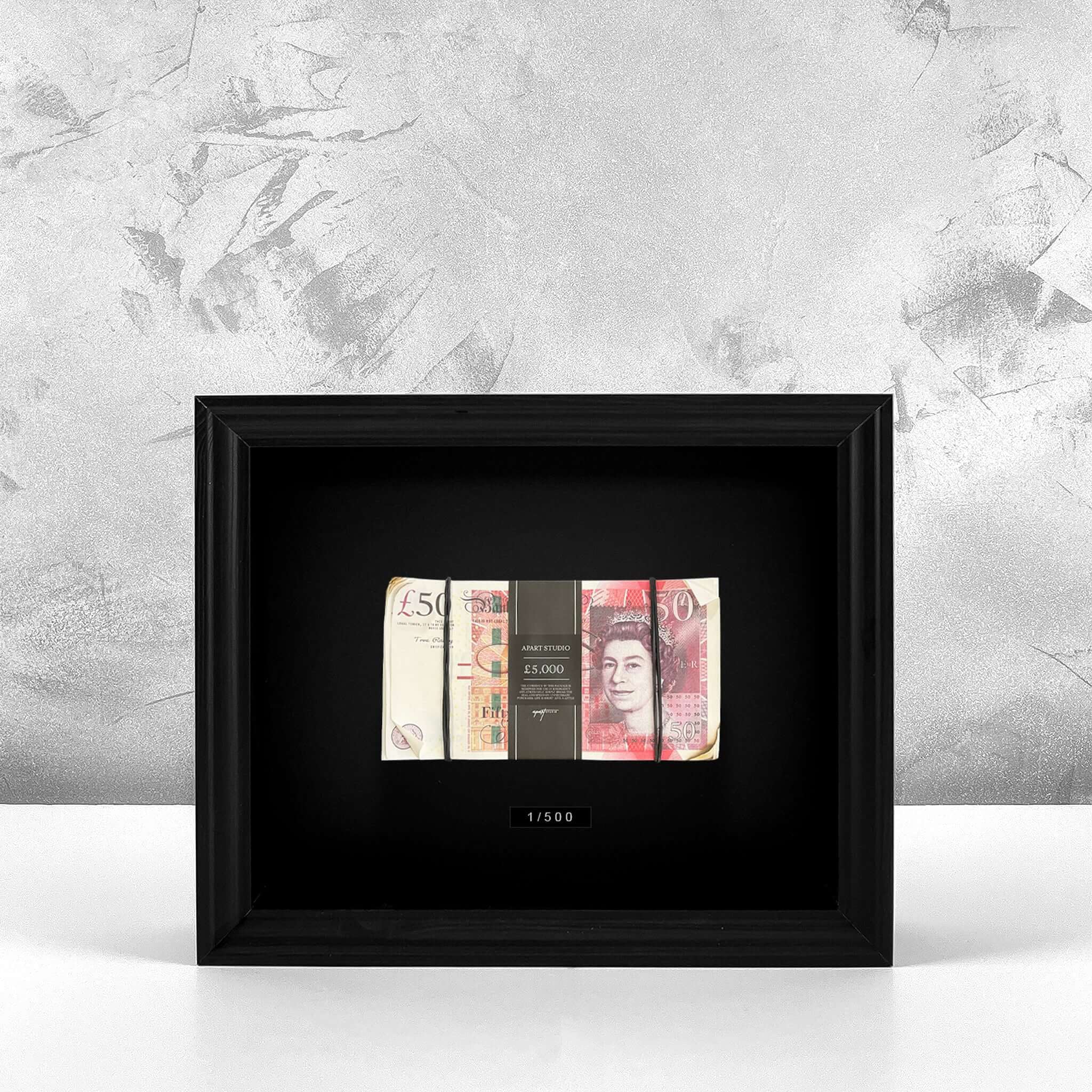 Aged Stacked Frame GBP front view, single stack of aged British pound notes behind glass in a black frame by Apart Studio